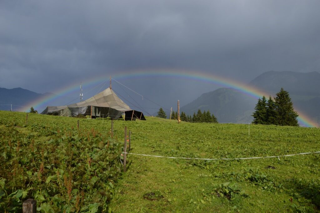 Regenbogen über dem Zeltlager der Jungwacht Baden in den Bergen.