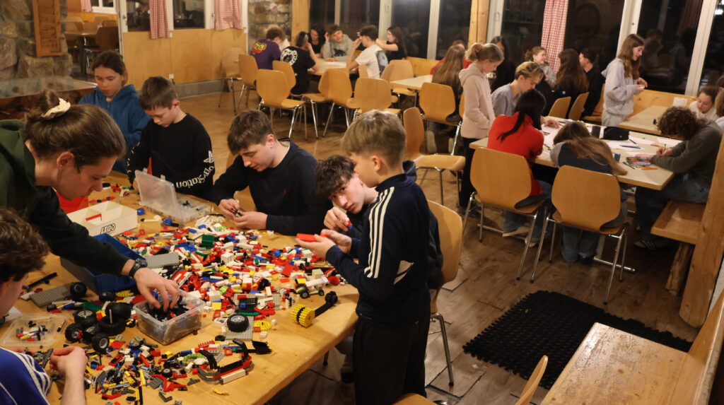 Kinder beschäftigen sich gemeinsam an einem Tisch mit bunten Bausteinen.